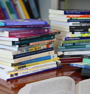 Two stacks of journals with the top of one open in front.