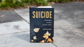 Book cover of Suicide by John Bateson featuring falling leaves.